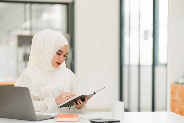 Красива мусульманська бізнес-леді в хіджабі старанно працює над своїм комп'ютером, демонструючи професіоналізм і відданість своїй роботі
 - Фото, зображення