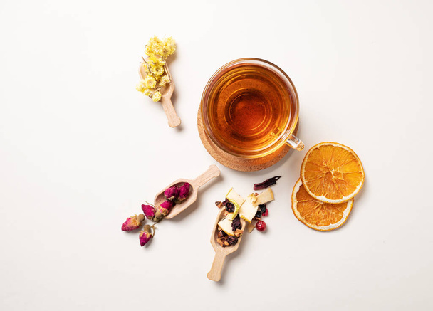 A cup of herbal tea with dried flowers, fruits and berries. The concept of healthy eating. Top view and copy space. - Photo, Image