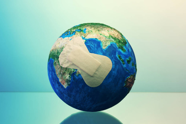  Conceptual image of Earth planet with adhesive plaster - Photo, Image