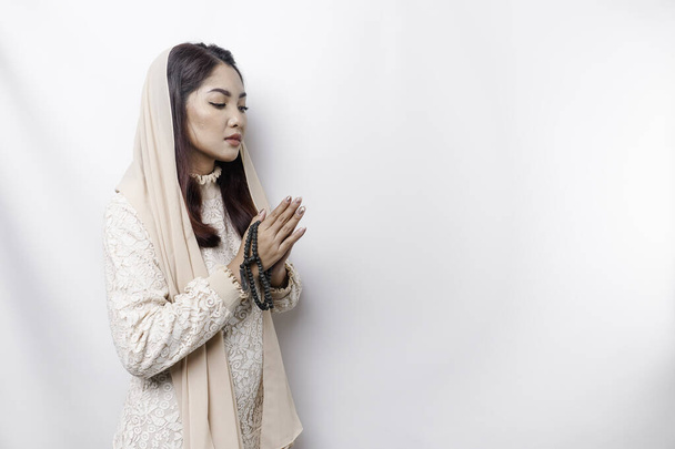 Portrait of a young beautiful Asian Muslim woman wearing a headscarf gesturing Eid Mubarak greeting - Fotografie, Obrázek