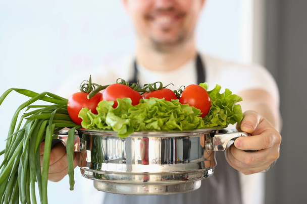 Cocinar es la celebración de ensalada de tomates y cebollas verdes en cacerola. Mejorar la salud a través del concepto de nutrición y vitaminas - Foto, imagen