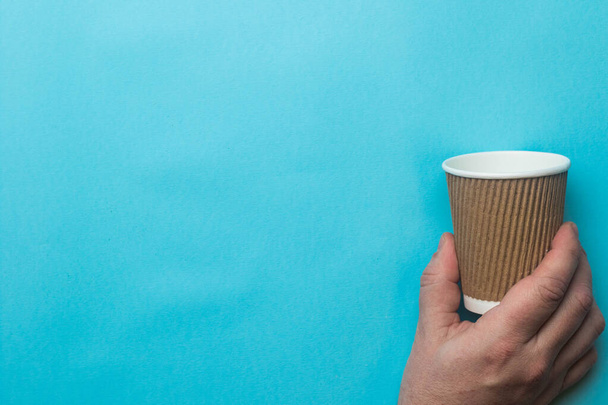 An empty coffee cup grasped by a hand - Φωτογραφία, εικόνα