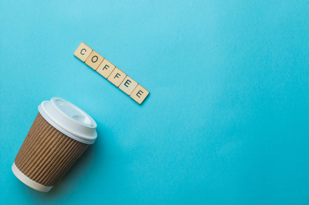 A paper coffee cup and lid with a sign reading coffee on a blue background - Photo, image