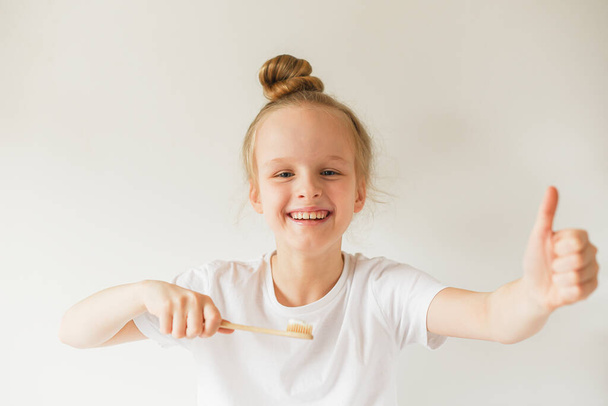 Happy Little Girl Cepillarse los dientes, Eco Cepillo de dientes orgánico de madera, Higiene dental, Noche de la mañana Concepto saludable Estilo de vida - Foto, imagen