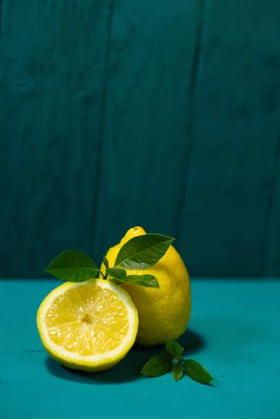 Juicy fresh lemons and leaves on a beautiful blue background - Photo, image