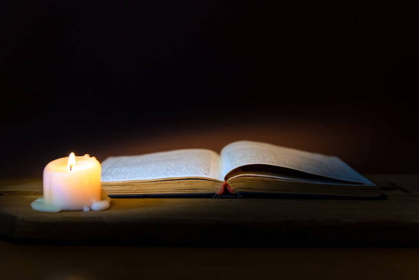 Понятное дело, Библия и свеча на старой деревянной тарелке.. - Фото, изображение