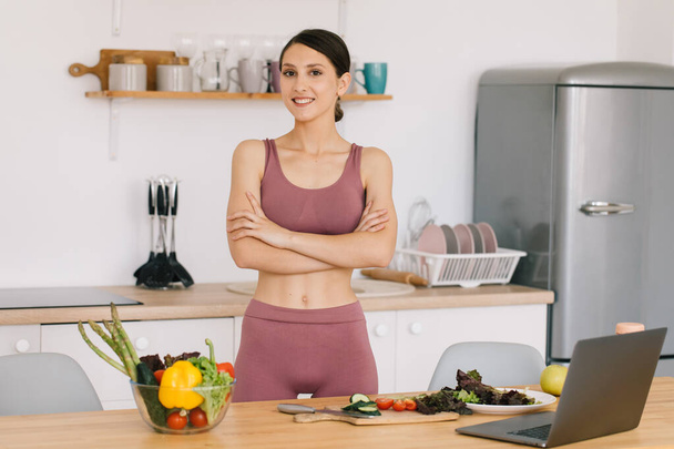 Retrato de blogueiro mulher desportiva feliz à mesa com legumes frescos, conceito de alimentação saudável - Foto, Imagem