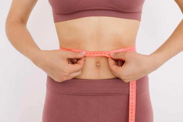Donna felice misura il righello la pancia. Il concetto di dieta e perdita di peso. - Foto, immagini