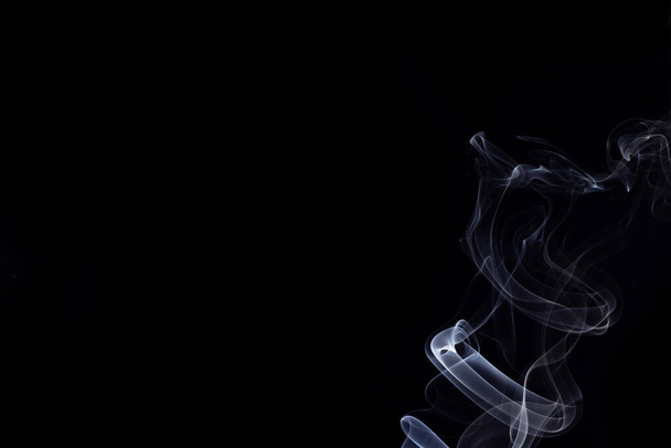 Eine abstrakte Form von weißem Rauch aus Weihrauch mit schwarzem Hintergrund. - Foto, Bild