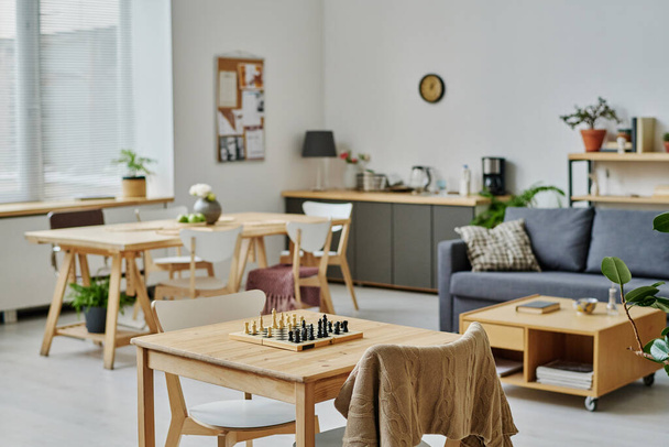 Οριζόντια εικόνα του σύγχρονου δωματίου με καναπέ και τραπέζι για επιτραπέζια παιχνίδια σε οίκο ευγηρίας - Φωτογραφία, εικόνα