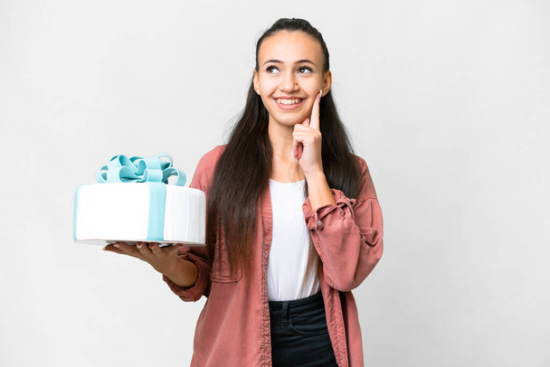 Young Arabian woman holding birthday cake over isolated white background thinking an idea while looking up - Foto, immagini