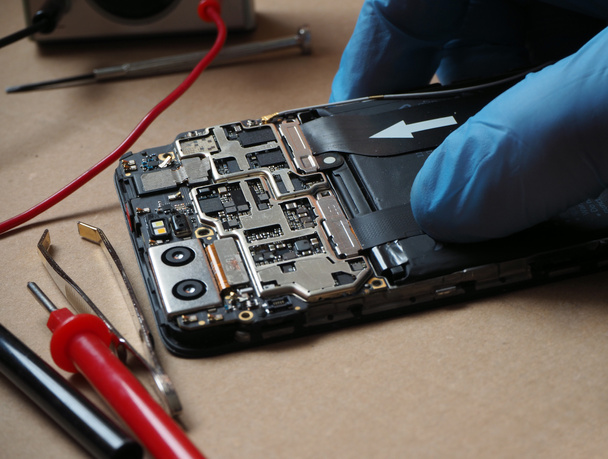 IT technician repair or cleaning smartphone in technical service.Smartphone parts and tools for recovery. Cell phone circuit board.  - Foto, imagen