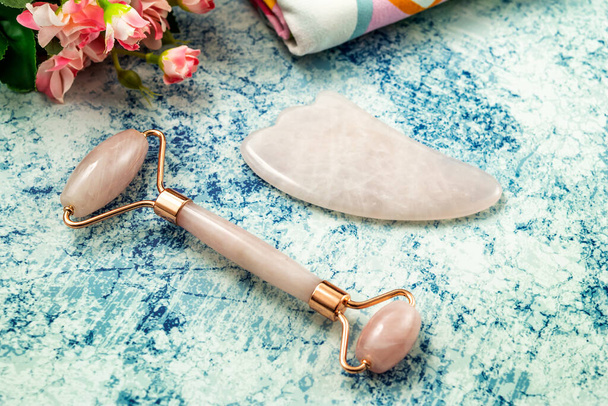 Jade Roller and Gua Sha for beauty facial massage therapy with towel. Flat lay on marble background - 写真・画像