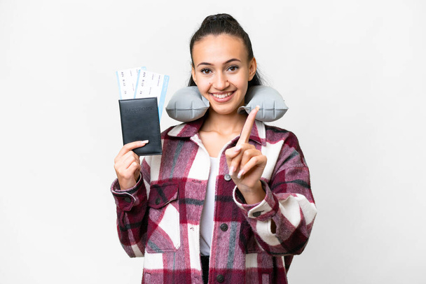 Mladá cestovatelka drží pas nad izolovaným bílým pozadím ukazující a zvedající prst - Fotografie, Obrázek