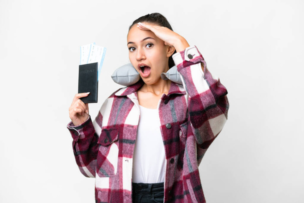 Νεαρή Traveler γυναίκα κρατώντας ένα διαβατήριο πάνω από απομονωμένο λευκό φόντο κάνει χειρονομία έκπληξη, ενώ κοιτάζοντας προς τα πλάγια - Φωτογραφία, εικόνα
