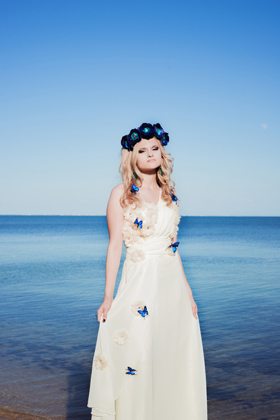 Κορίτσι κοντά στη θάλασσα, σε ένα λευκό φόρεμα και το στεφάνι - Φωτογραφία, εικόνα