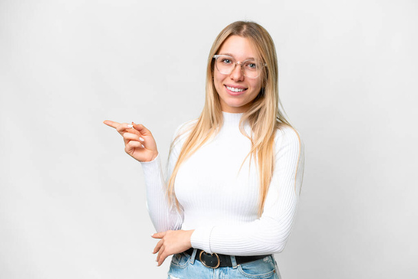 Young pretty blonde woman over isolated white background pointing finger to the side - Fotografie, Obrázek