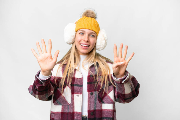 Joven mujer rubia bonita con manguitos de invierno sobre fondo blanco aislado contando nueve con los dedos - Foto, Imagen