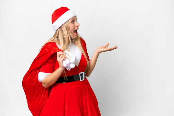 Young blonde woman with christmas hat over isolated white background with surprise facial expression - Foto, Imagem