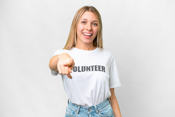 jonge vrijwilliger vrouw over geïsoleerde witte achtergrond verrast en wijzen naar voren - Foto, afbeelding