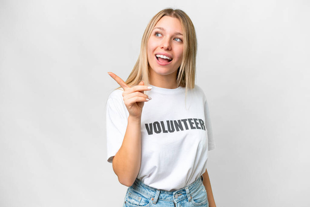Junge freiwillige Frau vor isoliertem weißen Hintergrund, die die Lösung erkennt, während sie den Finger hebt - Foto, Bild