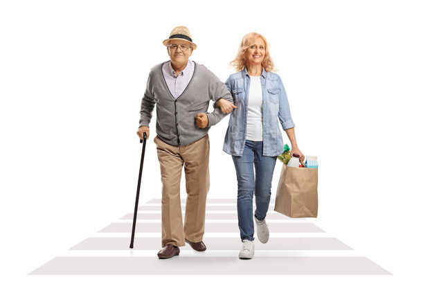 Woman crossing street and helping her senior father with grocery bags isolated on white background - Foto, imagen
