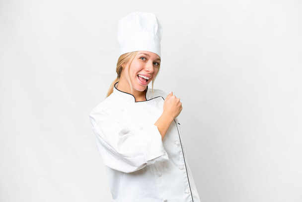 Young chef woman over isolated white background celebrating a victory - 写真・画像