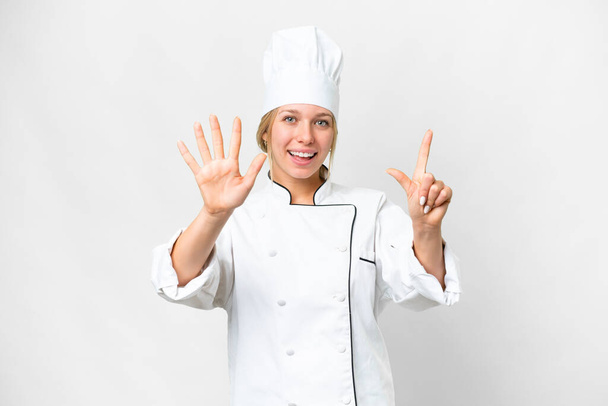 Genç aşçı kadın izole edilmiş beyaz arka planda yediyi parmaklarıyla sayıyor - Fotoğraf, Görsel