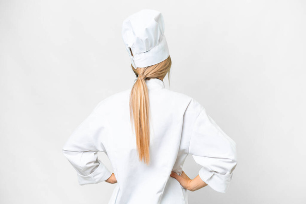 Young chef woman over isolated white background in back position - Foto, imagen