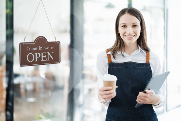Pienen yrityksen perustaminen ja avaaminen, nuori aasialainen nainen, jolla on hymyilevät kasvot esiliinassa seisomassa kahvilan tiskin edessä. Yrityksen omistaja, Ravintola, Barista, Kahvila, Online SME. - Valokuva, kuva