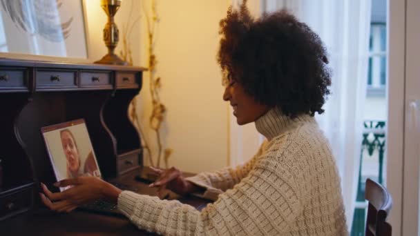 Szczęśliwa dama rozmawiająca na video czacie przy laptopie. Podekscytowana kobieta używająca komputera do rozmów wideo w domu. Afrykański amerykański uśmiech dziewczyna słuchanie rozmówca patrząc w kamery internetowej w domu - Materiał filmowy, wideo