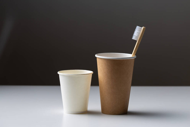 Toothbrush in a cardboard ecological cardboard cup, hygiene health care. - Foto, afbeelding