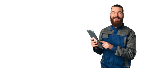 Banner formato colpo di un ingegnere maschio sorridente e in possesso di un tablet vicino spazio copia. - Foto, immagini