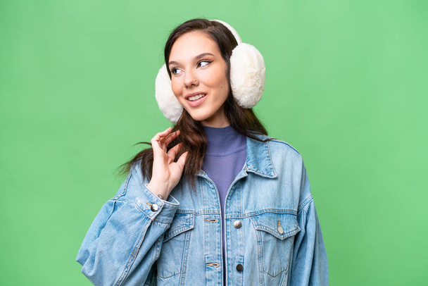Jeune femme caucasienne portant des manchons d'hiver sur fond isolé pensant une idée - Photo, image