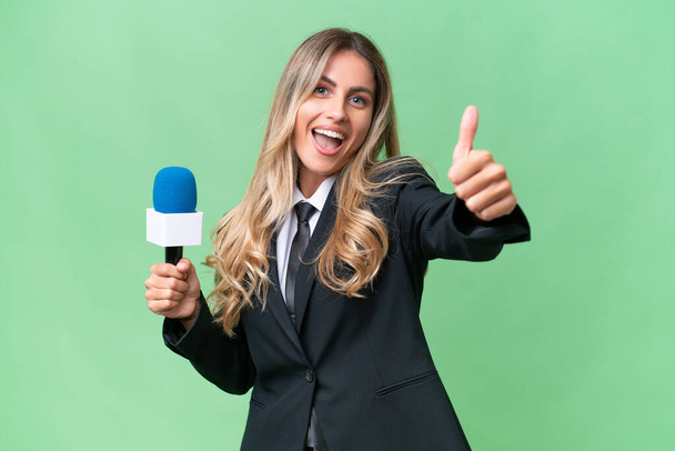 Young pretty Uruguayan tv presenter over isolated background with thumbs up because something good has happened - Photo, Image