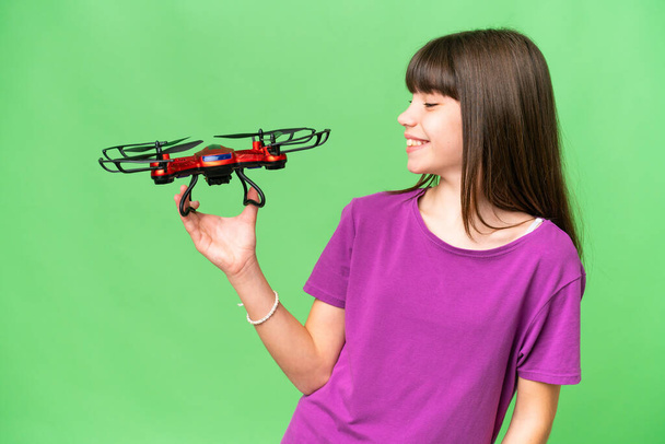 Kis kaukázusi lány kezében egy drón felett elszigetelt háttér boldog kifejezés - Fotó, kép