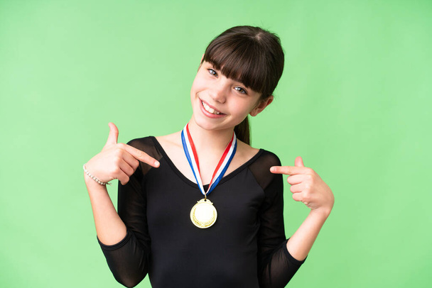 Little caucasian girl with medals over isolated background proud and self-satisfied - Fotó, kép