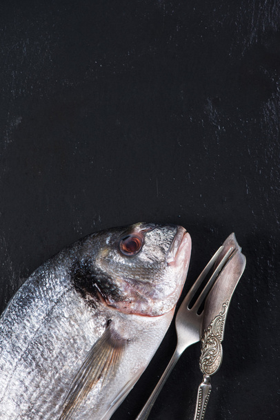 Peixe-marinho inteiro fresco com faca e garfo, conceito de alimentação
 - Foto, Imagem
