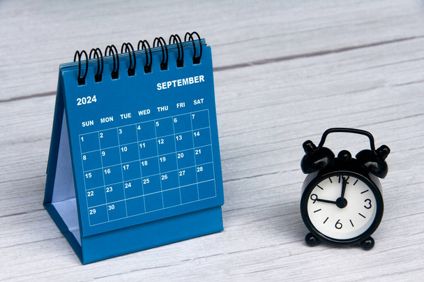 Eylül 2024 takvimi ahşap masa ve alarm saati üzerinde kişiselleştirilebilir metin alanı ile. Aylık takvim kavramı ve kopyalama alanı - Fotoğraf, Görsel