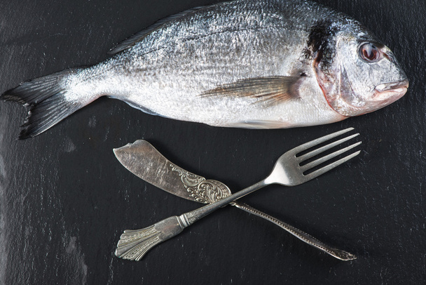 Vers hele zeevis met mes en vork, eten concept - Foto, afbeelding
