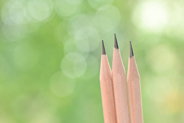 tre matita di legno tagliente su sfondo verde sfocatura natura con bokeh - Foto, immagini
