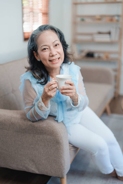 Porträt einer älteren Asiatin, die Tee für die Gesundheit trinkt - Foto, Bild