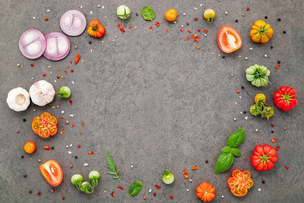 The ingredients for homemade pizza set up on dark stone background. - Foto, afbeelding