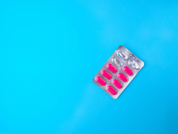 Вид сверху Антибиотики таблетки, которые были использованы на синем фоне с копировальным пространством. - Фото, изображение