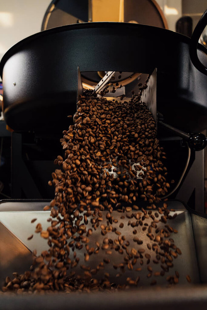 Geroosterde koffiebonen gieten uit release parachute in moderne fabriek - Foto, afbeelding