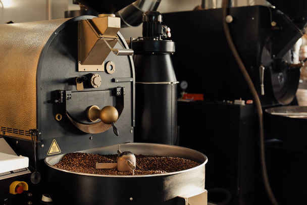 Máquina profesional en proceso de tostado y mezcla de granos de café en la fábrica industrial moderna - Foto, imagen