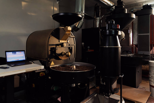 Machine professionnelle en cours de torréfaction et de mélange des grains de café dans l'usine industrielle moderne - Photo, image