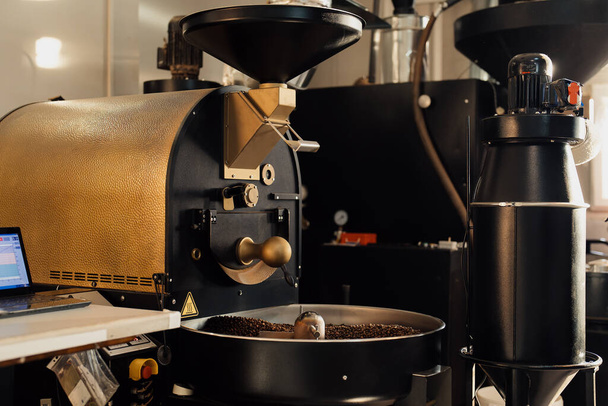 Professional machine in process of roasting and mixing coffee beans in modern industrial factory - Foto, Bild