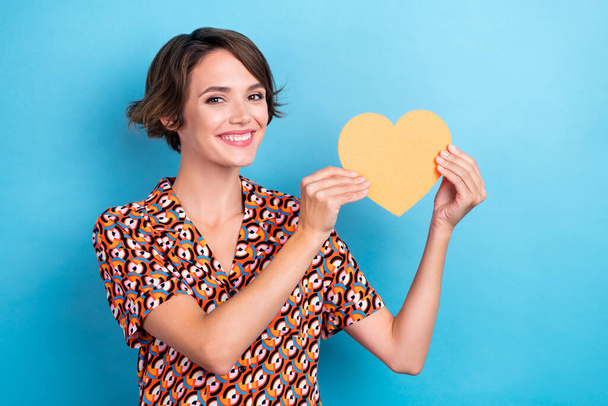 Photo of excited pretty woman wear print blouse smiling holding heart card isolated blue color background. - Фото, изображение