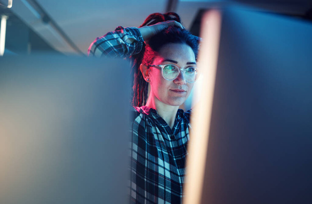 Siber güvenlik, kötü amaçlı yazılım ve kadın hacker gece vakti bodrumda bir bilgisayar üzerinde çalışıyor. Bir dijital dönüşüm ağına sızan bir kadın kodcuyla veritabanı, şifre ve fidye yazılımı. - Fotoğraf, Görsel
